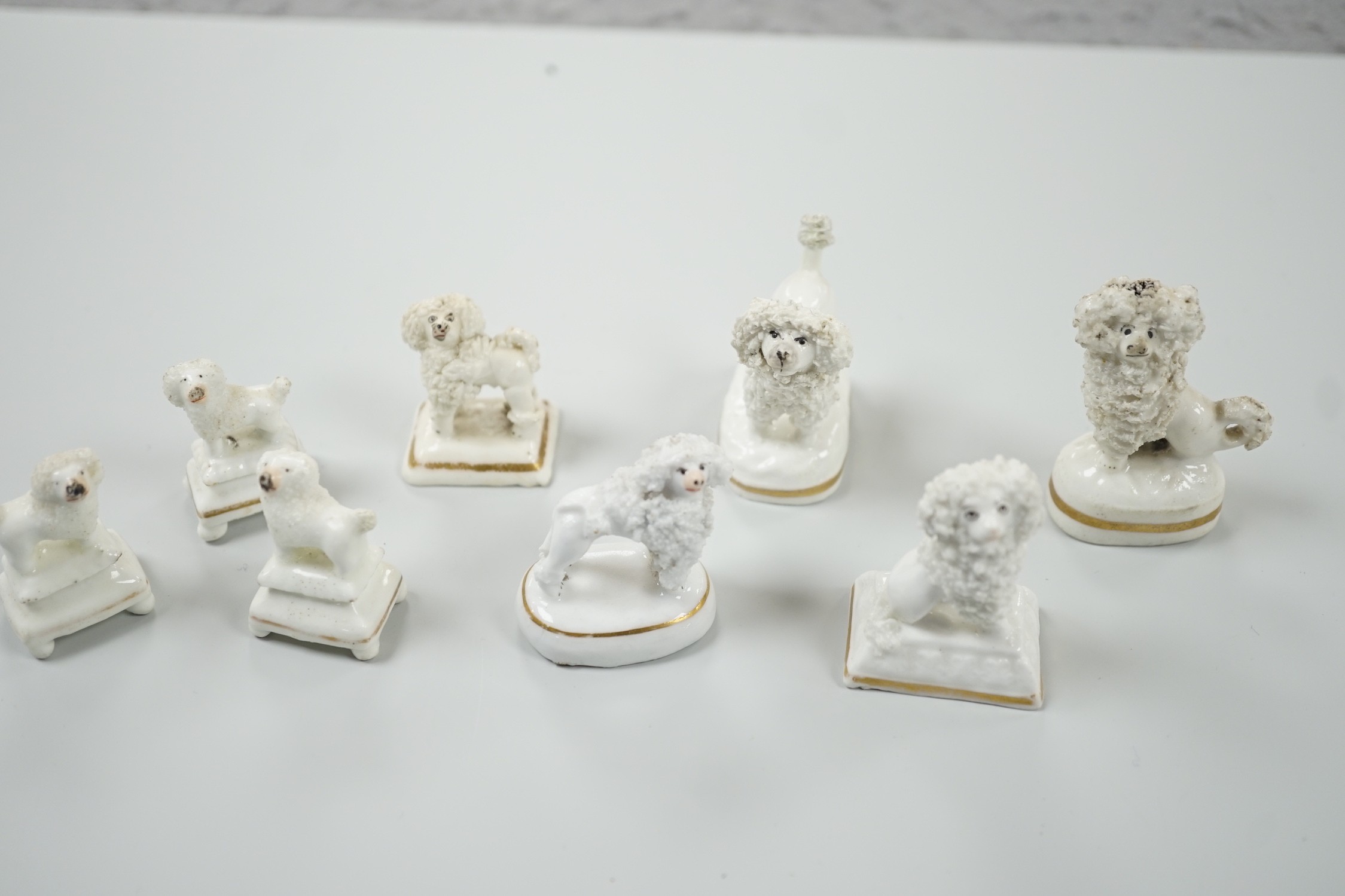 Four small Staffordshire porcelain models of poodles, together with five toy Staffordshire models of poodles, c.1830-50. Largest 5cm tall, Provenance- Dennis G Rice collection